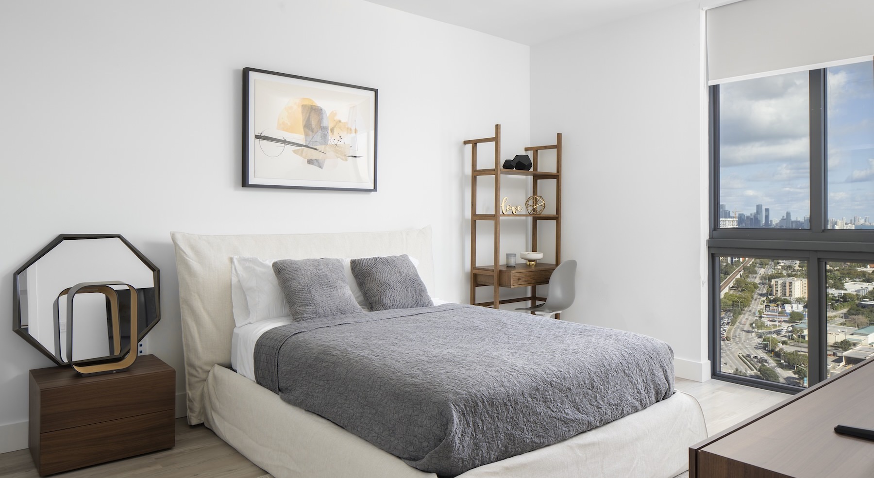 bedroom with large windows and night stands on each side of a bed