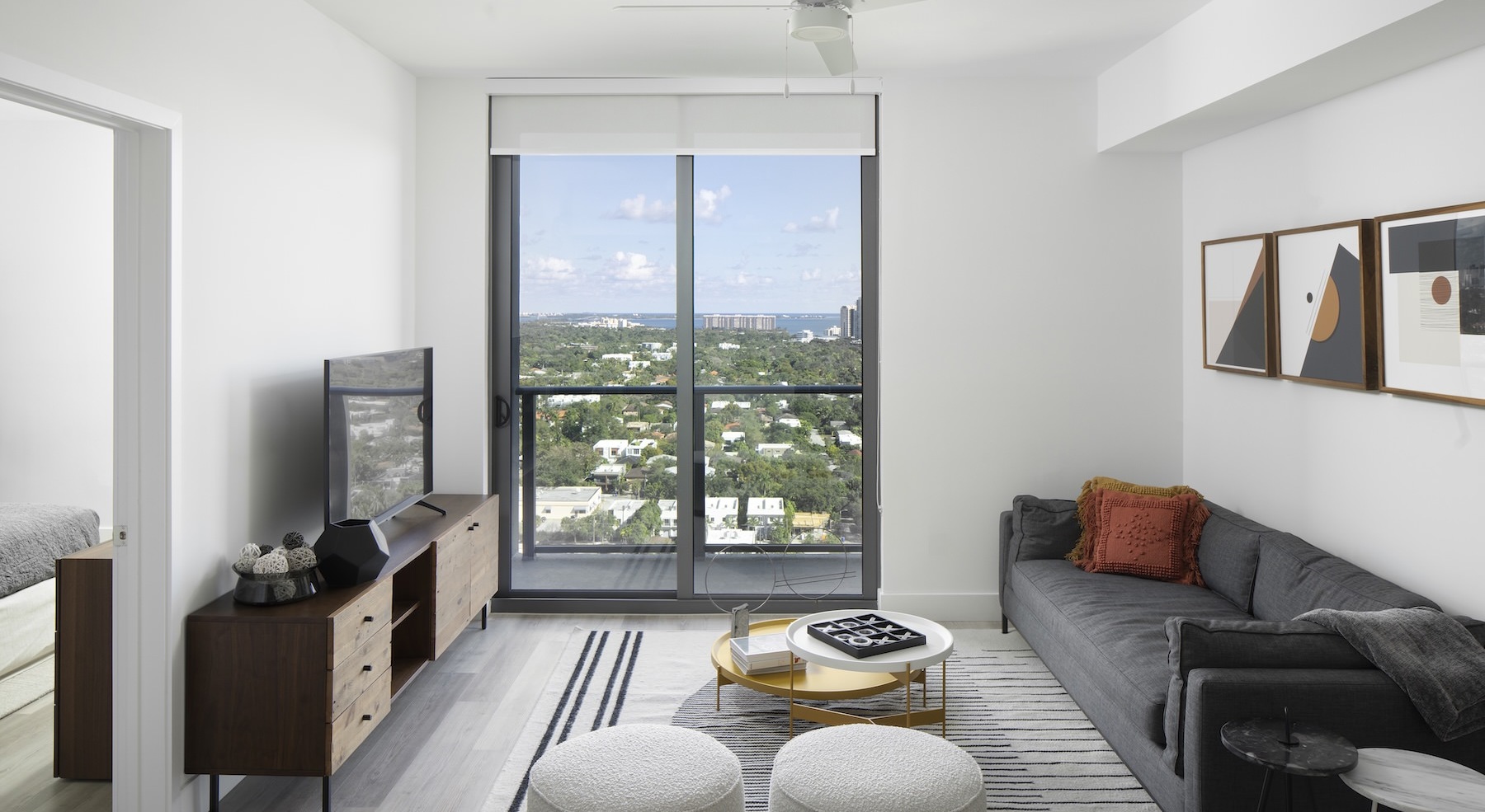 living room with a large window, couch, coffee table and tv