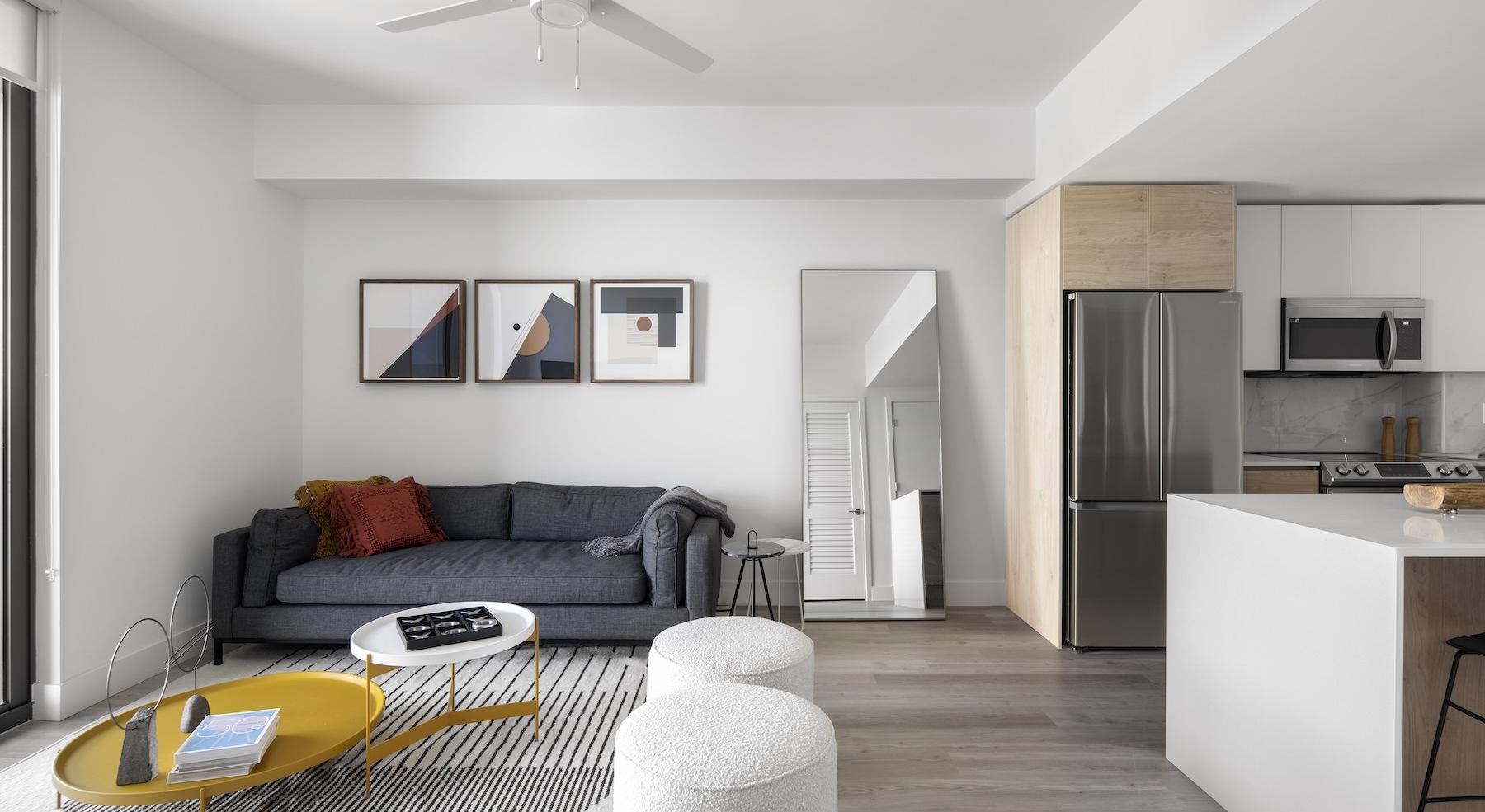 a living room with a couch and a table connected to a kitchen