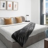 a bed in a room with side tables and a large window