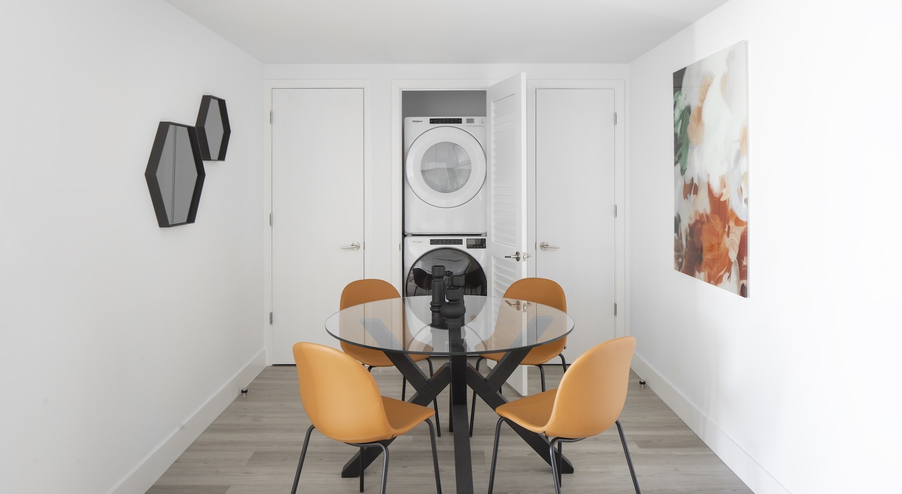 a table with seating and a washer and dryer behind it